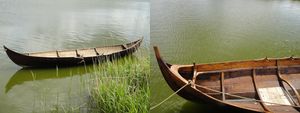 Two somewhat longish skiffs (simple wooden rowboats/rowing boats) in water