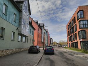A street in the old metalworking district with new expensive residential apartment buildings visible on both sides.